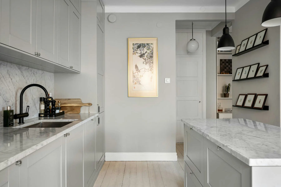 Vaaleanharmaa keittiö: vaaleat marmoritasot ja musta hana.