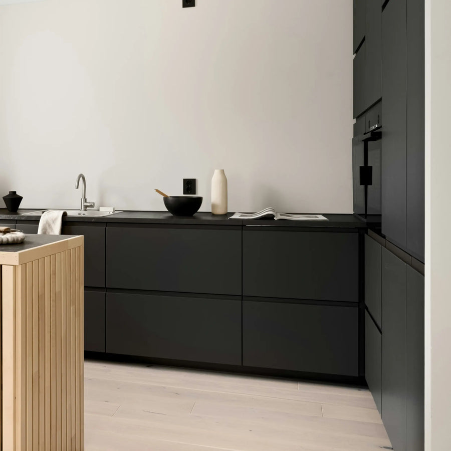 Kaunis musta keittiö mattapintaisilla mittatilauskalusteilla ja skandinaavisella ilmeellä.
